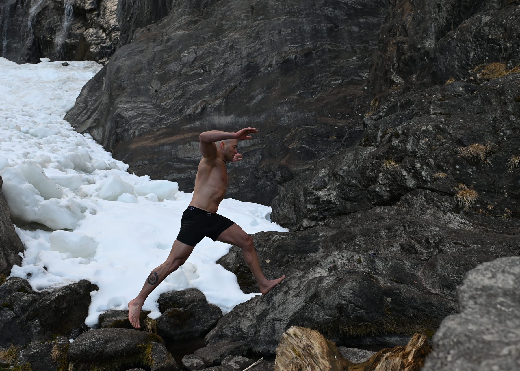 Claudio Lombardo esegue un movimento di equilibrio tra roccia e neve