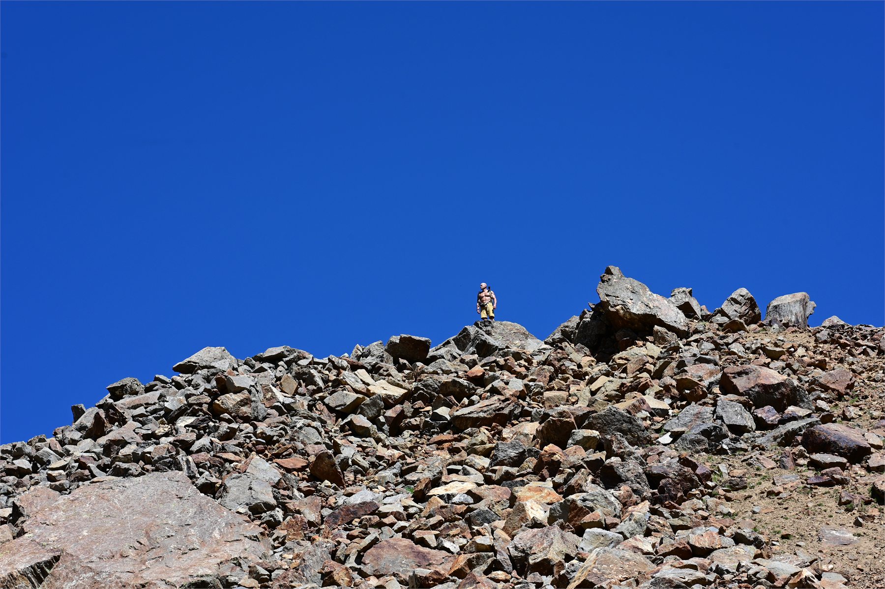Claudio Lombardo raggiunge una cresta rocciosa sotto il cielo limpido d’alta quota