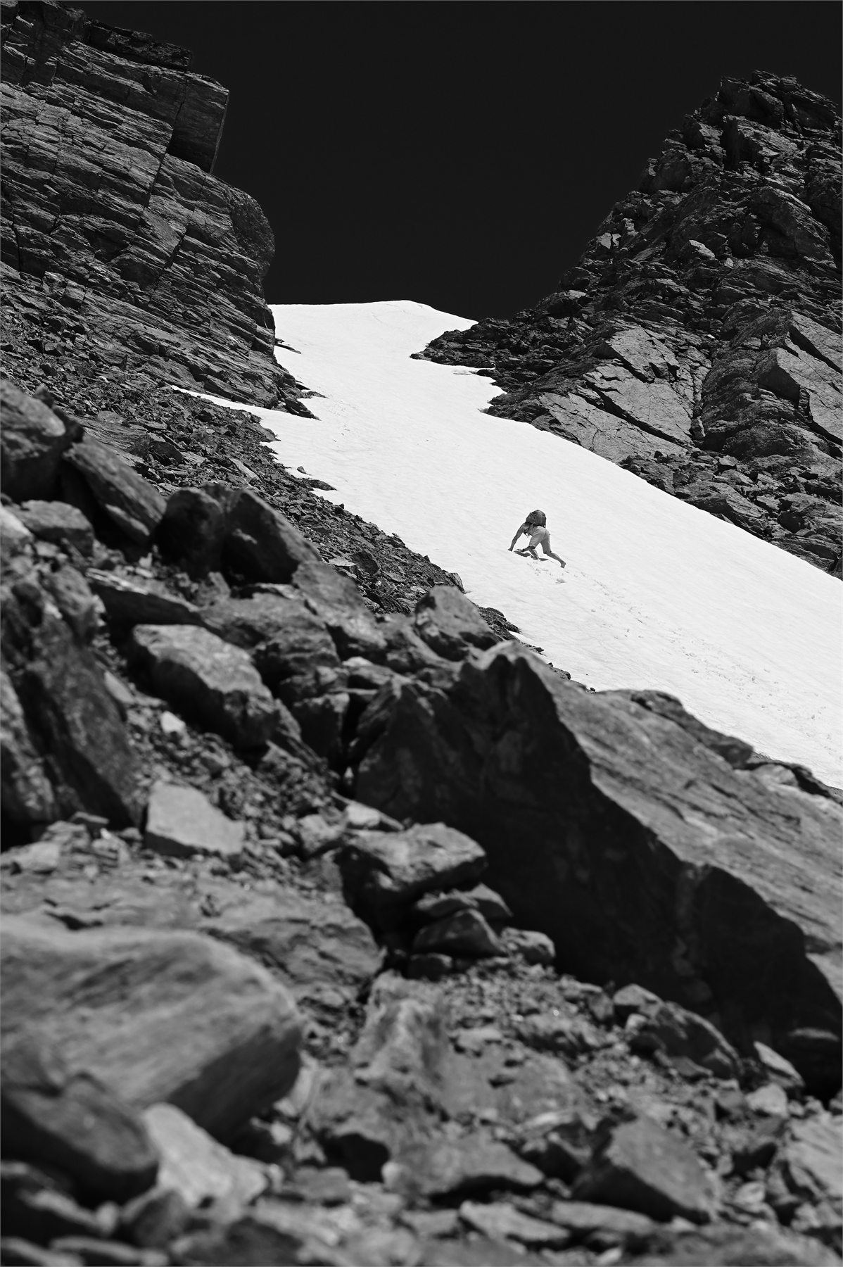 Claudio Lombardo affronta a piedi nudi un ripido nevaio tra due pareti rocciose