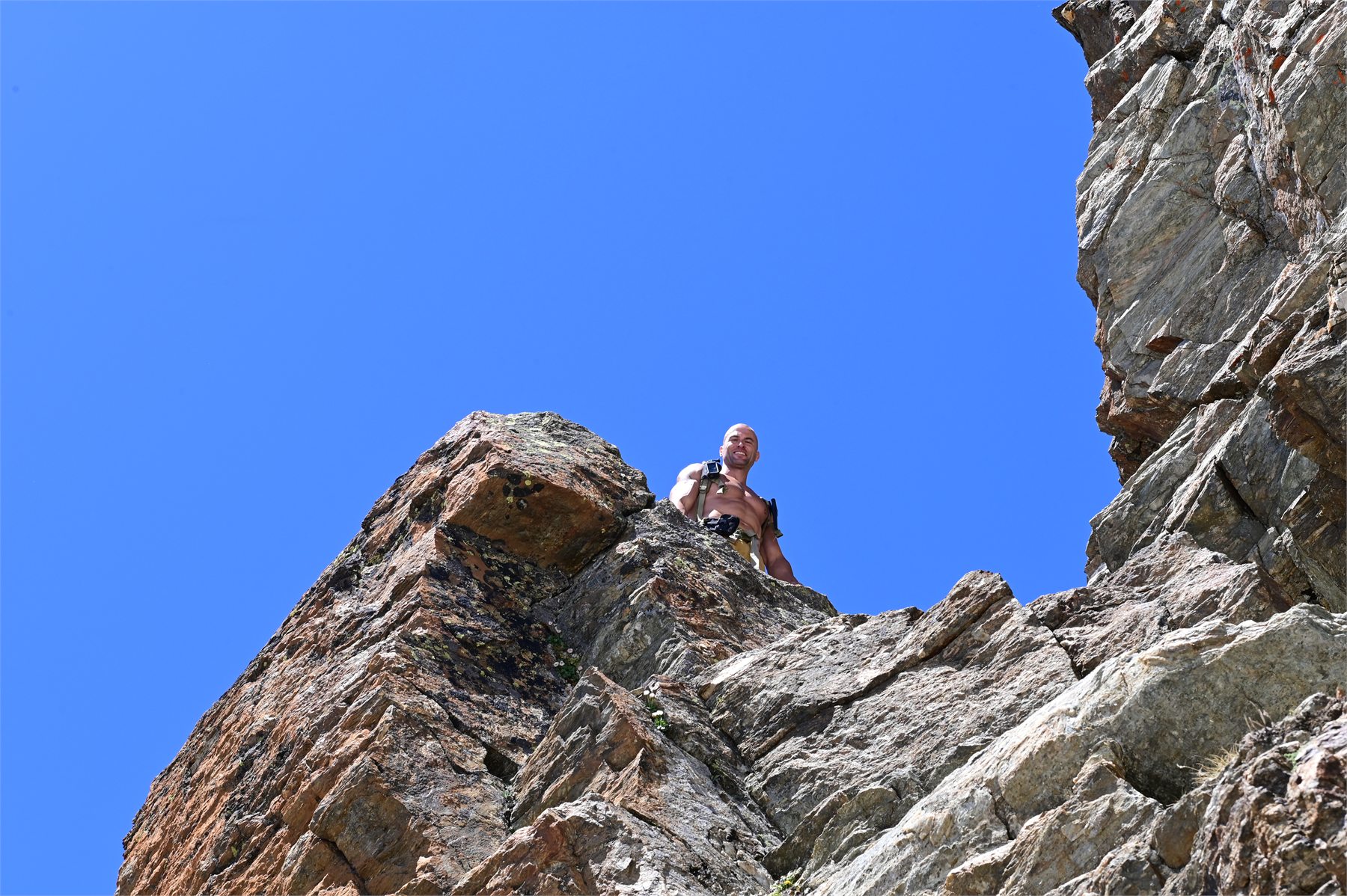 Claudio Lombardo osservato dal basso tra grandi rocce durante una sessione in montagna